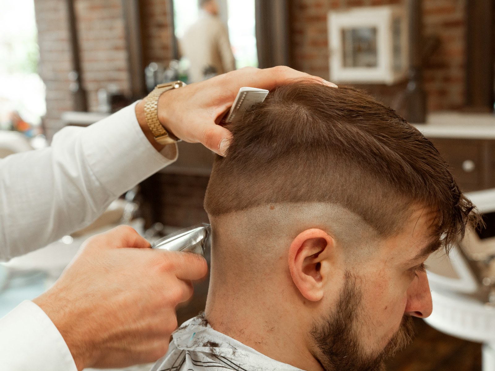 Barbero marcando un degradado con la máquina