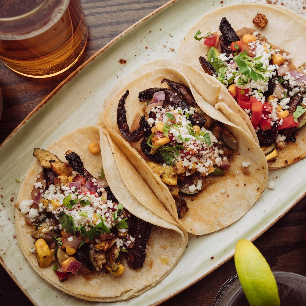 Plato de tacos con carne, elote y queso fresco